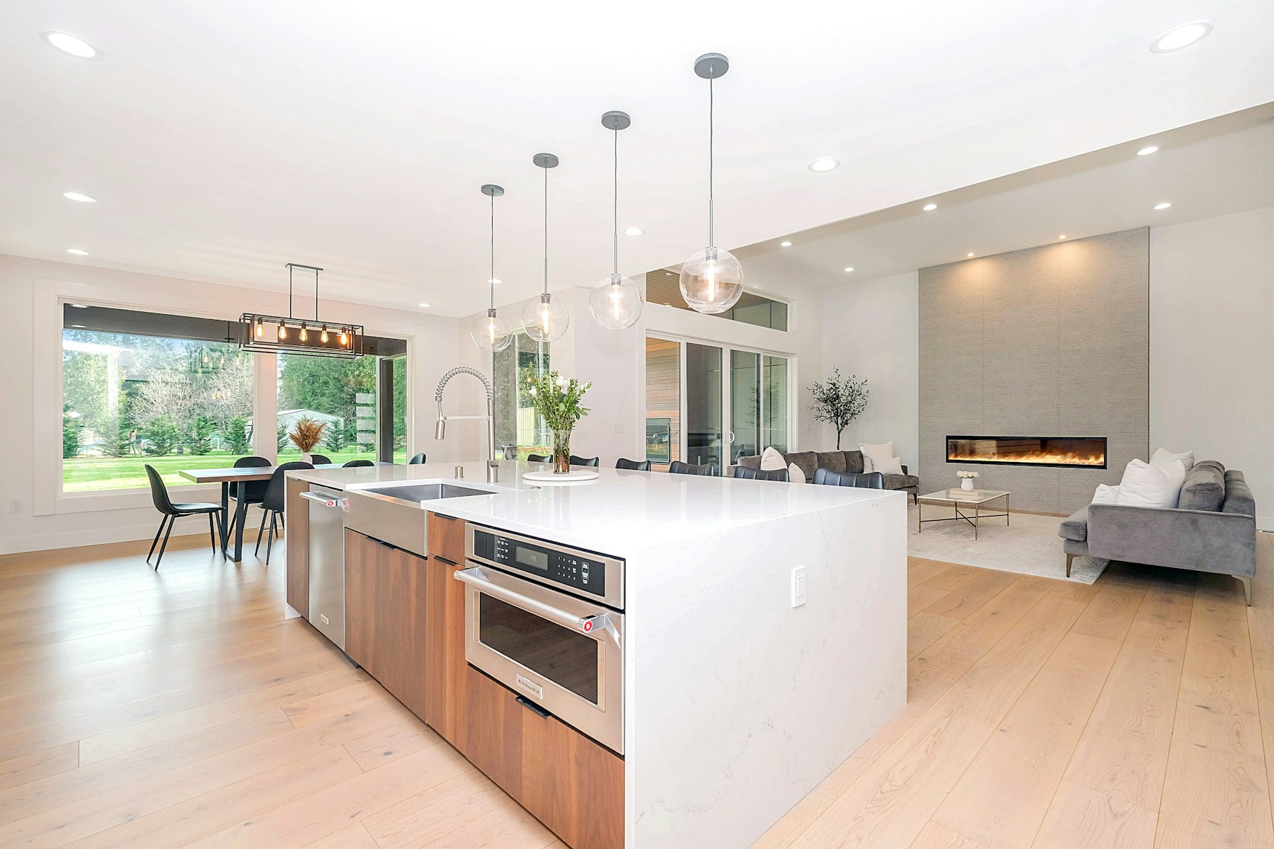Finished open-plan kitchen with new cabinetry, countertops, lighting, and flooring